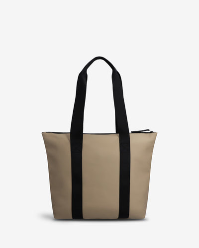 A structured tote bag in beige with two vertical black side panels and black shoulder straps, shown against a plain light gray background.