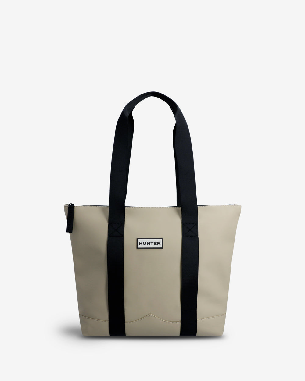 A Hunter tote bag in beige canvas with black webbed handles and vertical trim, featuring a small white 'Hunter' brand label on the front.