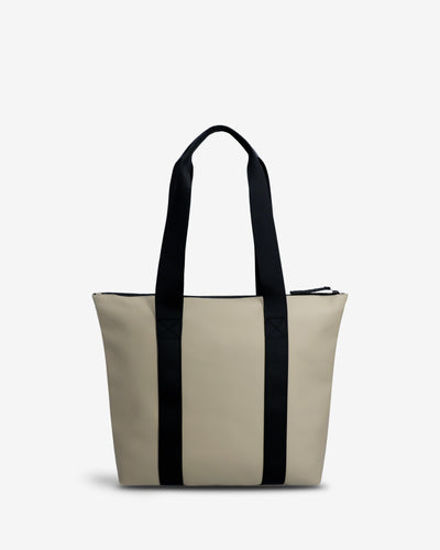 A structured tote bag in light beige with two prominent black vertical side straps and black shoulder handles, shown against a plain white background.