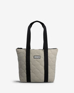 A light beige quilted tote bag with black handles and a black vertical stripe detail, featuring a small Hunter brand label on the front.