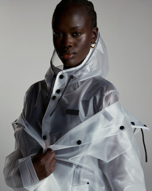 Shows a model wearing the Izzy clear matte 'Hunter' branded Unisex Downpour Hooded Jacket