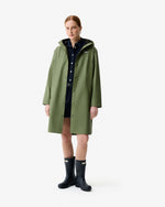 Displays a model wearing the Olive Ellis 'Hunter' branded Women's Olive Ellis PU Raincoat