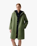 Displays a model wearing the Olive Ellis 'Hunter' branded Women's Olive Ellis PU Raincoat
