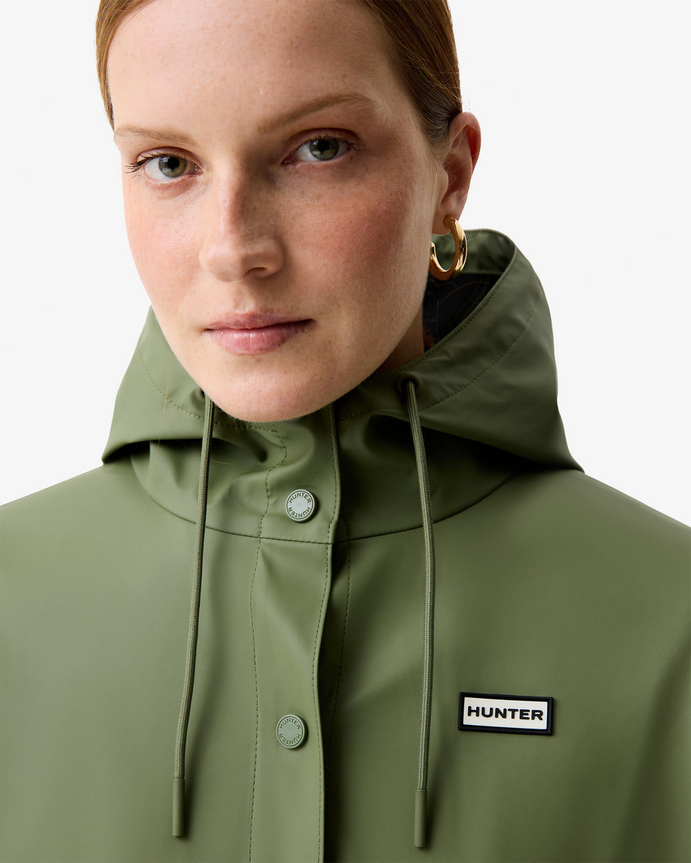 Displays a model wearing the Olive Ellis 'Hunter' branded Women's Olive Ellis PU Raincoat