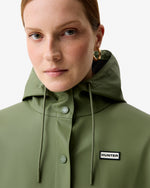 Displays a model wearing the Olive Ellis 'Hunter' branded Women's Olive Ellis PU Raincoat