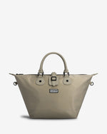 A light beige Hunter tote bag with dual top handles, a front buckle strap detail, and a small Hunter brand plaque on the front, set against a plain light gray background.
