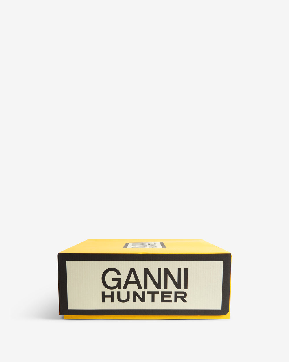 Displays the packaging for the Chocolate Brown 'Hunter' branded women's GANNI X Hunter Balmoral Ankle Boot