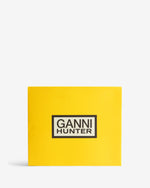 Displays the packaging for the Chocolate Brown 'Hunter' branded women's GANNI X Hunter Balmoral Ankle Boot