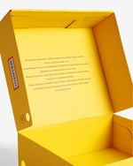 Displays the open packaging for the Chocolate Brown 'Hunter' branded women's GANNI X Hunter Balmoral Ankle Boot
