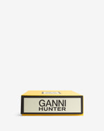 Displays the packaging of the Dark Olive 'Hunter' branded Unisex GANNI X Hunter Tall Adjustable Downpour Wellington Boot