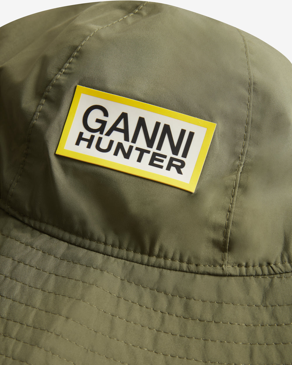Displays the Green 'Hunter' branded unisex Green GANNI X Hunter Waterproof Bucket Hat featuring the Ganni x Hunter logo