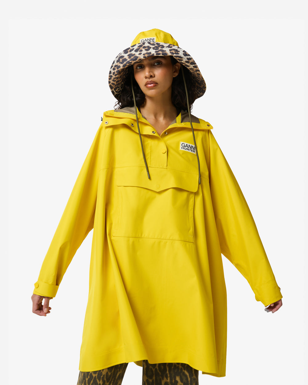 Displays a model wearing the Lemon 'Hunter' branded Unisex Ganni X Hunter Waterproof Poncho