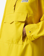 Displays a model wearing the Lemon 'Hunter' branded Unisex Ganni X Hunter Waterproof Poncho featuring the details on the pocket