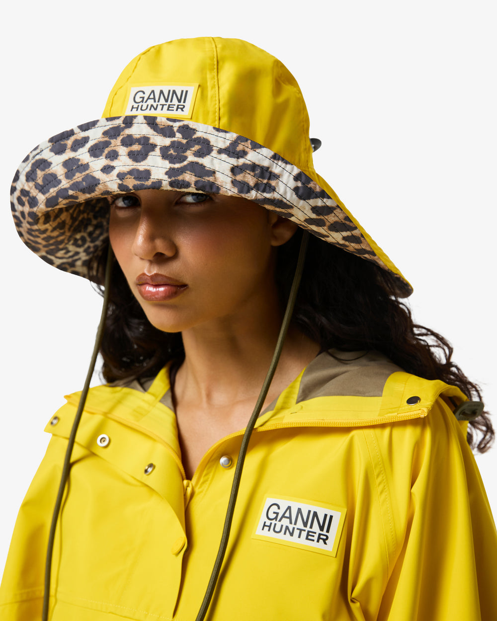 Displays a model wearing the lemon 'Hunter' branded unisex GANNI X Hunter Waterproof Bucket Hat