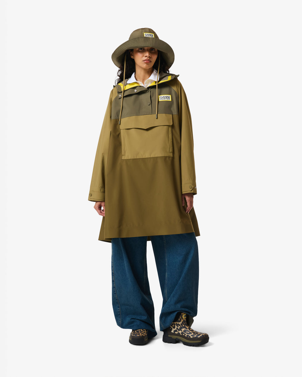 Displays a model wearing the Green 'Hunter' branded Unisex GANNI X Hunter Waterproof Poncho