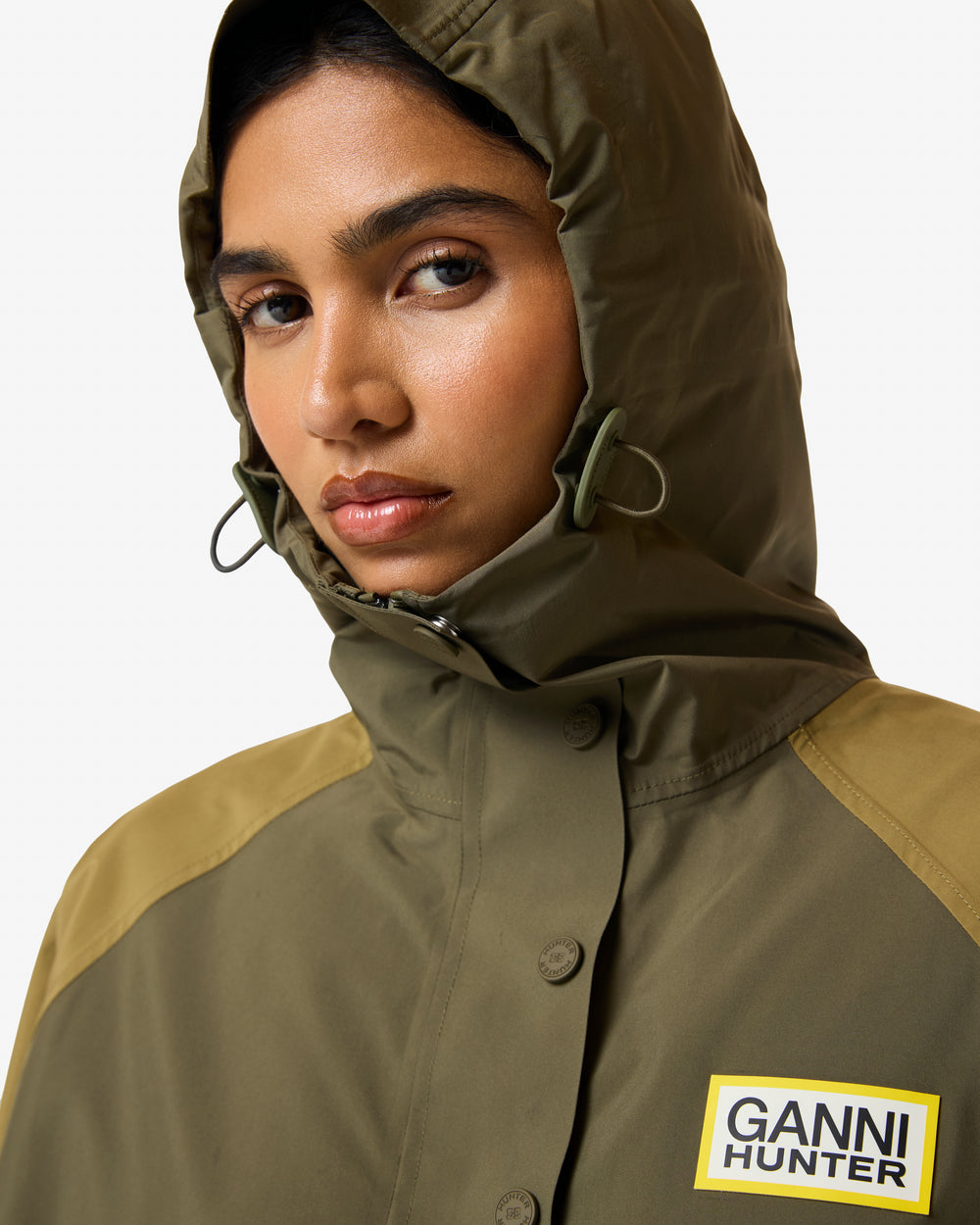 Displays a model wearing the Green 'Hunter' branded Unisex GANNI X Hunter Waterproof Poncho
