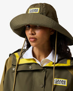 Displays a model wearing the Green 'Hunter' branded unisex Green GANNI X Hunter Waterproof Bucket Hat