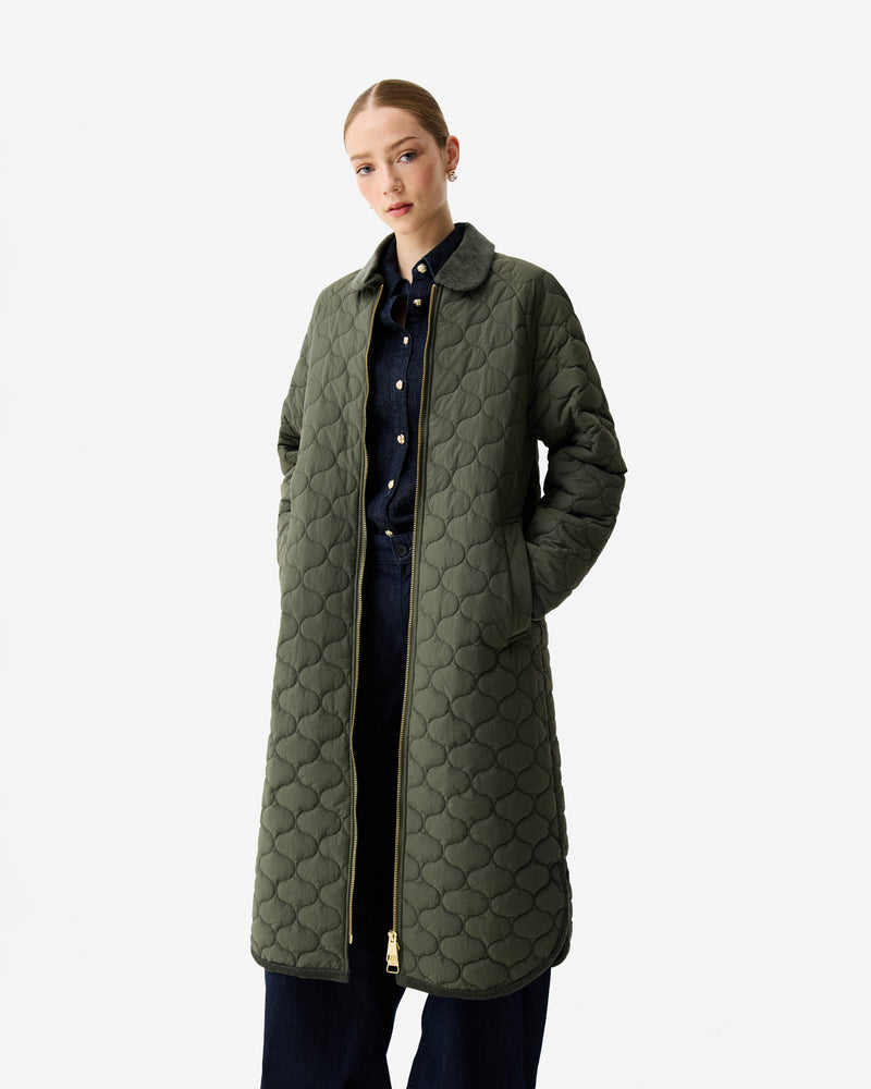 Displays a model wearing the Kambaba Green 'Hunter' branded Women's Fionn Long Quilted Coat