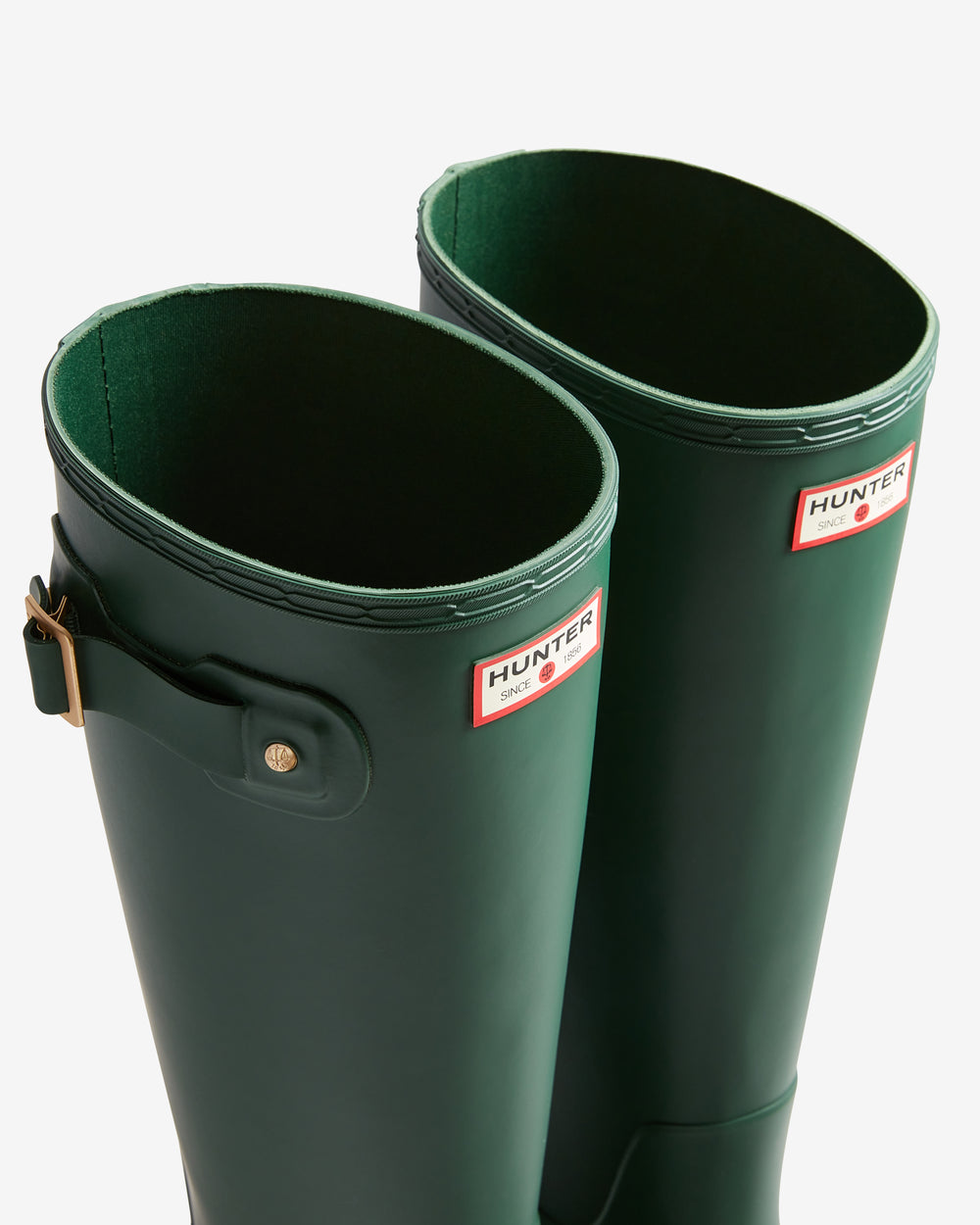Two green Hunter wellington boots on a white background