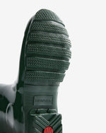 Close-up of a green rubber sole with 'Hunter' branding on a white background