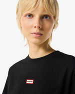 Displays a model wearing Black 'Hunter' branded Women's Essentials Logo Boxy Cropped T-Shirt