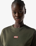 Displays a model wearing the Kambaba Green 'Hunter' branded Women's Essentials Logo Boxy Cropped T-Shirt