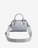 A light gray top-handle handbag with a matching shoulder strap, featuring the HUNTER brand name embossed on the strap, set against a plain light gray background.