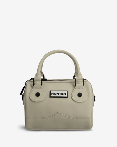 A light beige structured handbag with dual top handles, black hardware, and a white rectangular patch on the front featuring the black 'HUNTER' logo, set against a plain light gray background.