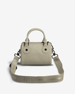 A light beige leather handbag with a top handle, double button closure, and an adjustable woven shoulder strap featuring the HUNTER logo, shown against a plain white background.