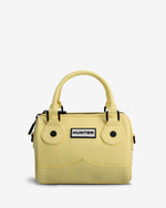 A light yellow structured handbag with a top handle, black hardware, and a white Hunter brand patch on the front, set against a plain light gray background.