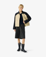 Displays a model wearing the Beige 'Hunter' branded Recrafted Cropped Jacket