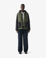 Displays a model wearing the Green 'Hunter' branded Women's Recrafted Quilted Jacket